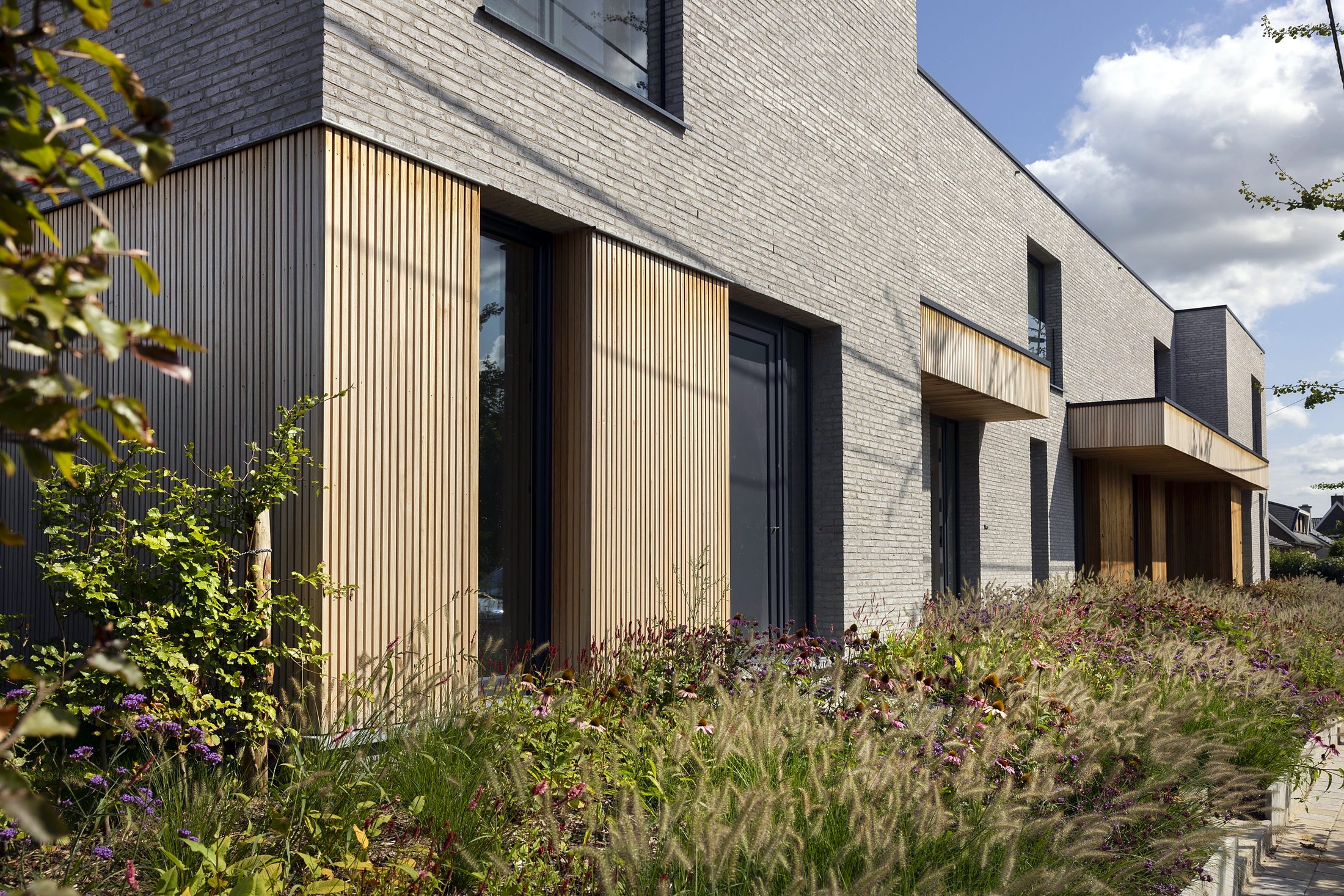 Woningen met lichte gevelsteen en houten gevelbekleding