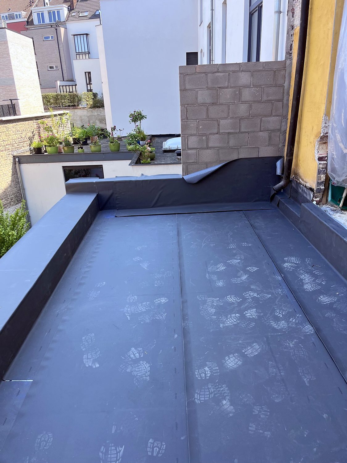 Plat dak in EPDM met opstanden tegen de gevel