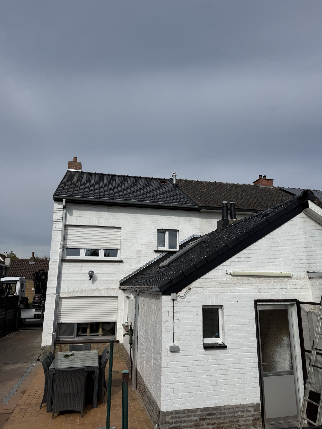 Achtergevel met vernieuwd dak op hoofdgebouw en bijgebouw